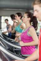 Smiling muscular woman on treadmill
