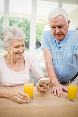 Happy senior couple listening to music