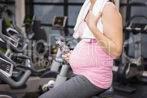 Mid section of pregnant woman on exercise bike