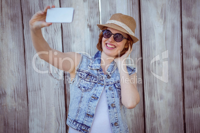 smiling hipster woman taking a selfie