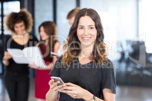 Portrait of businesswoman text messaging on smartphone