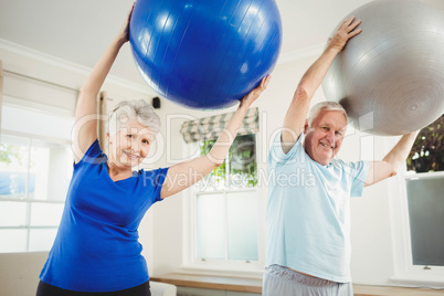 Senior couple exercising with exercise ball