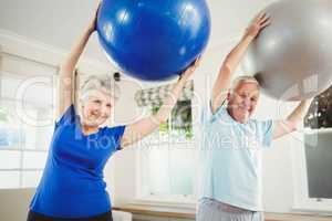 Senior couple exercising with exercise ball