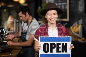 Portrait of a asian waiter showing open sign