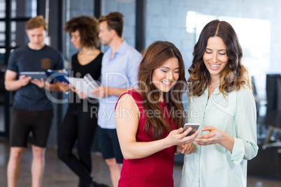 Women looking at smartphone and having discussion