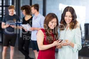 Women looking at smartphone and having discussion