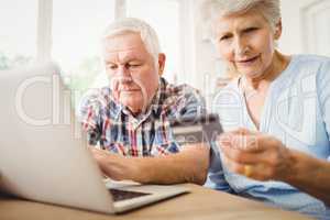 Senior couple paying bills online