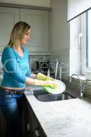 Pretty blonde woman doing house chores