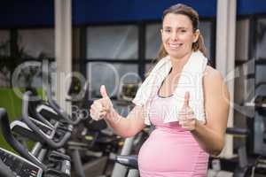 happy pregnant woman showing thumbs up