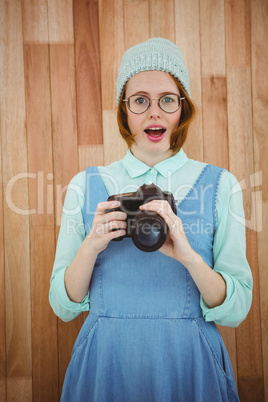 Red haired hipster holding camera