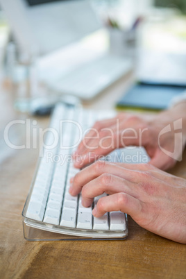 Masculine hands typing on keyboard