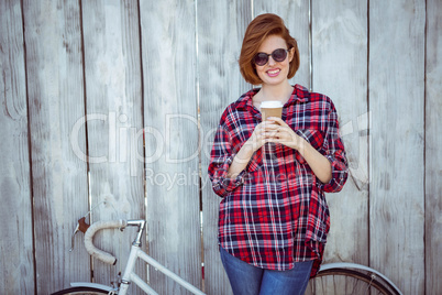 smiling hipster woman with coffee and a biycle