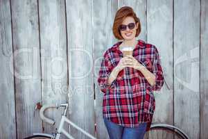smiling hipster woman with coffee and a biycle