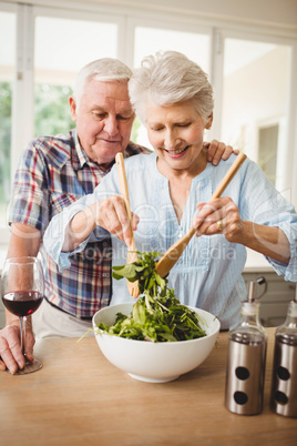 Senior couple preparing salad