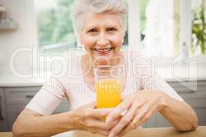 Happy senior woman having a glass of juice