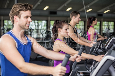 Fit people on elliptical bike