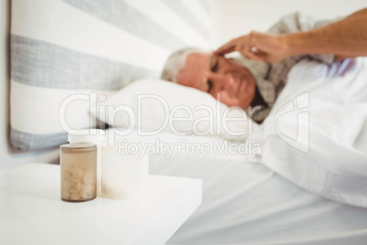 Pillboxes on a side table near bed