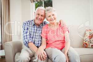 Senior couple sitting on sofa and smiling