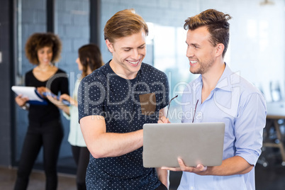 Men looking at laptop and having a discussion