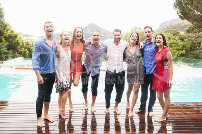 Beautiful young people standing near swimming pool