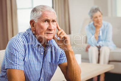 Worried senior man sitting on sofa