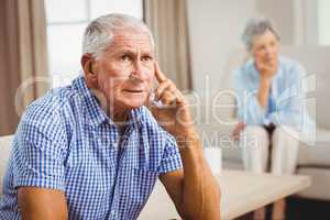 Worried senior man sitting on sofa