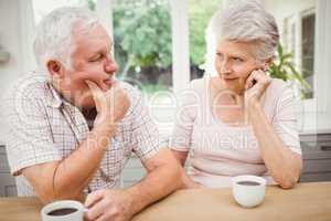 Senior couple talking to each other while having coffee