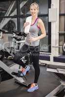 Fit woman standing next to exercise bike