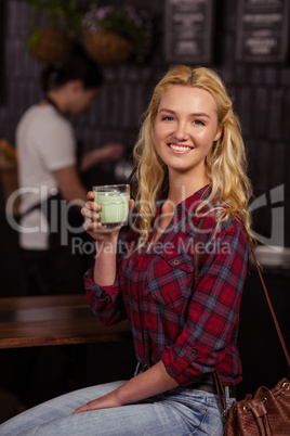 Smiling blonde drinking a beverage