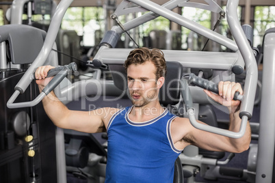 Fit man using weight machine