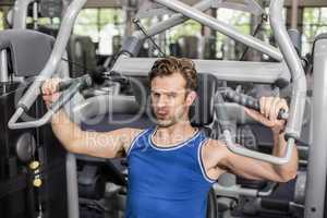 Fit man using weight machine