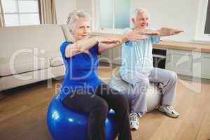 Senior couple exercising on exercise ball