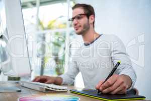 Handsome man working on computer and taking notes