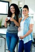 Portrait of pregnant lesbian couple standing together