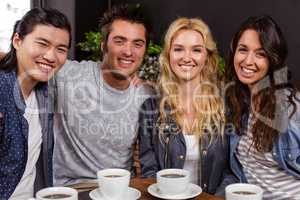 Smiling friends enjoying coffee together