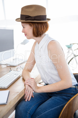 smiling hipster business woman looking at her computer