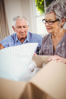 Senior couple unpacking a cardboard box