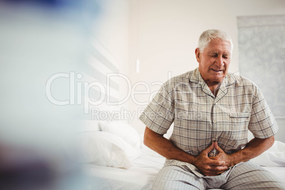 Sick senior man holding stomach