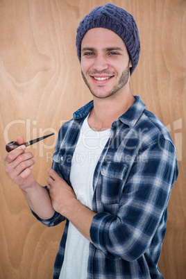 Handsome hipster smocking a pipe