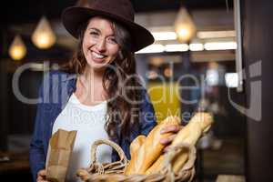 Smiling woman touching bread and looking at the camera