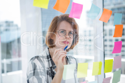 thoughtful hipster woman brainstorming over notes