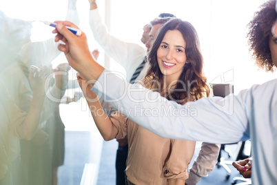 Businesspeople writing on white board