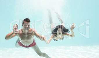 Couple enjoying underwater in swimming pool