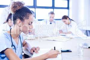 Female doctors writing on clipboard