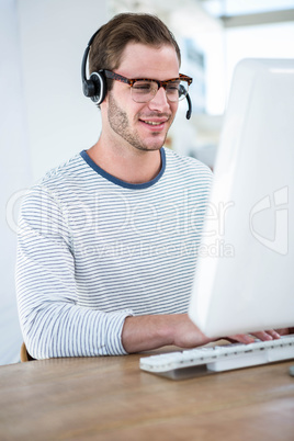 Handsome man working on computer with headset