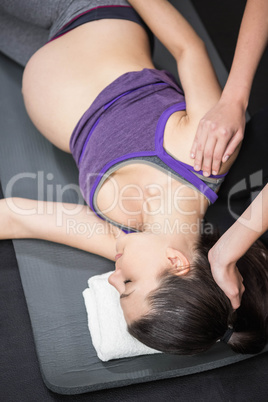 Trainer massaging pregnant woman