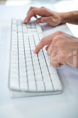 Close up view of a male hand typing on keyboard