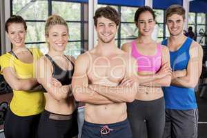 Athletic men and women posing arms crossed