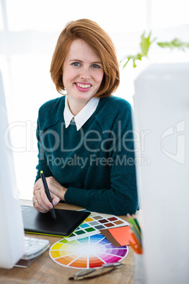 smiling hipster designer writing on a digital tablet