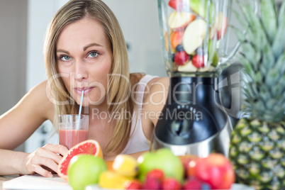 Pretty blonde woman holding her homemade smoothie